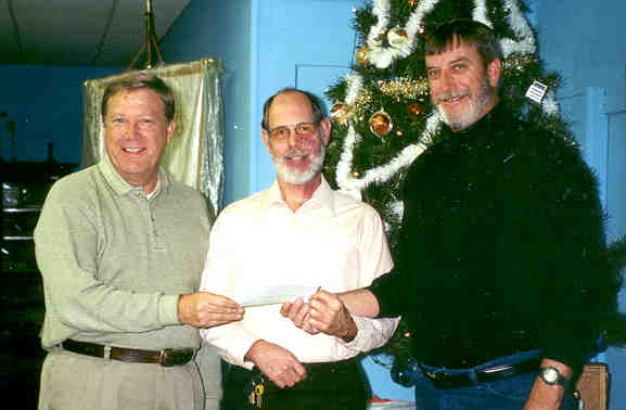 Picture of 3 men holding a check being donated to the Parsons State Hospital Endowment Association.